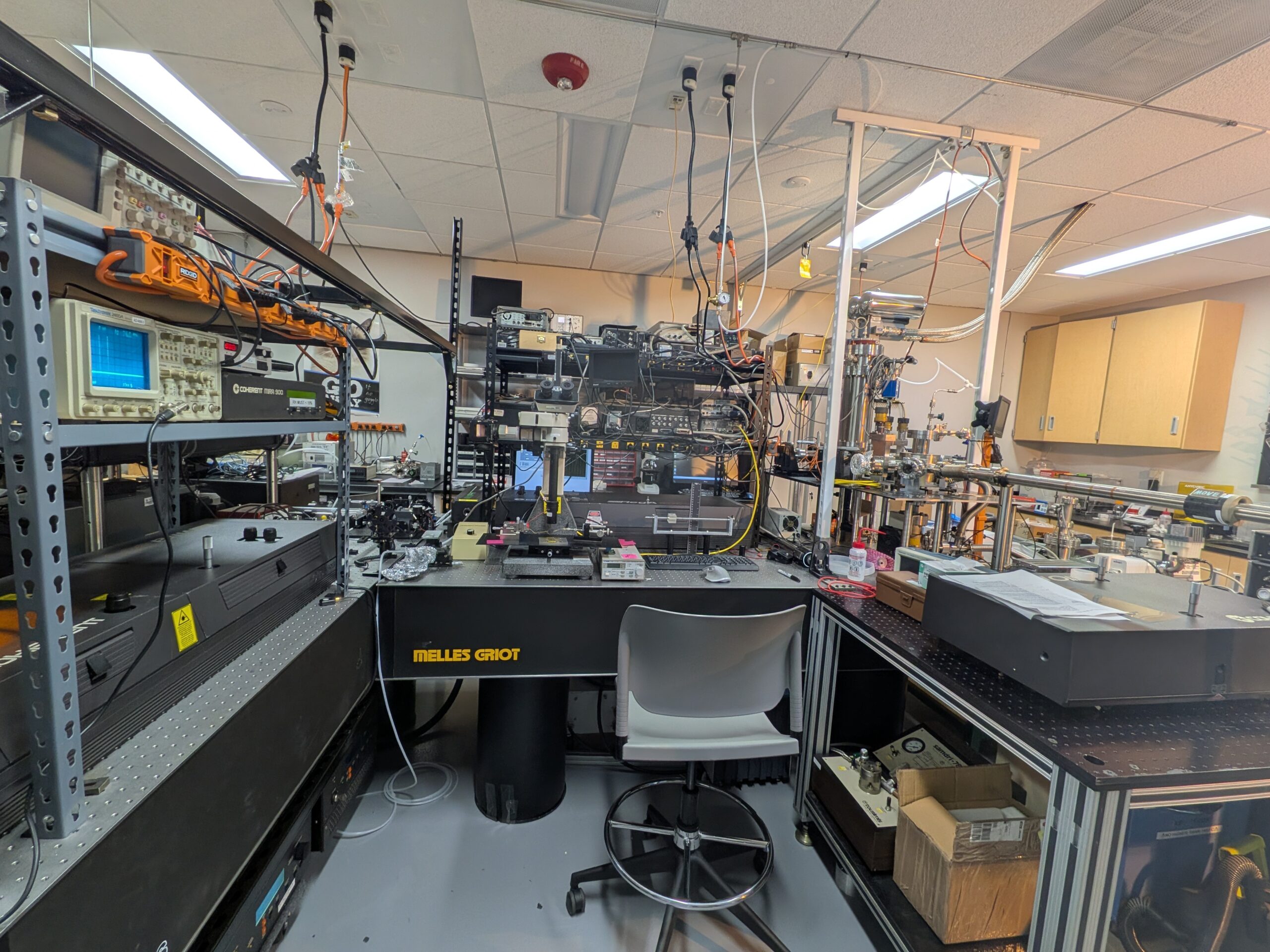 Optical table with oscilloscopes, laser enclosure, and vacuum plumbing